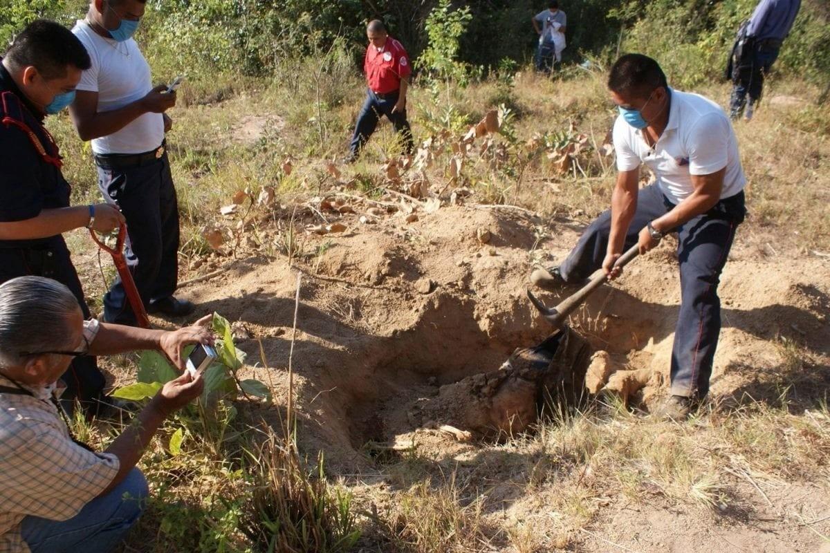 Personas sacando restos humanos de la fosa clandestina. Foto: La Orquesta.