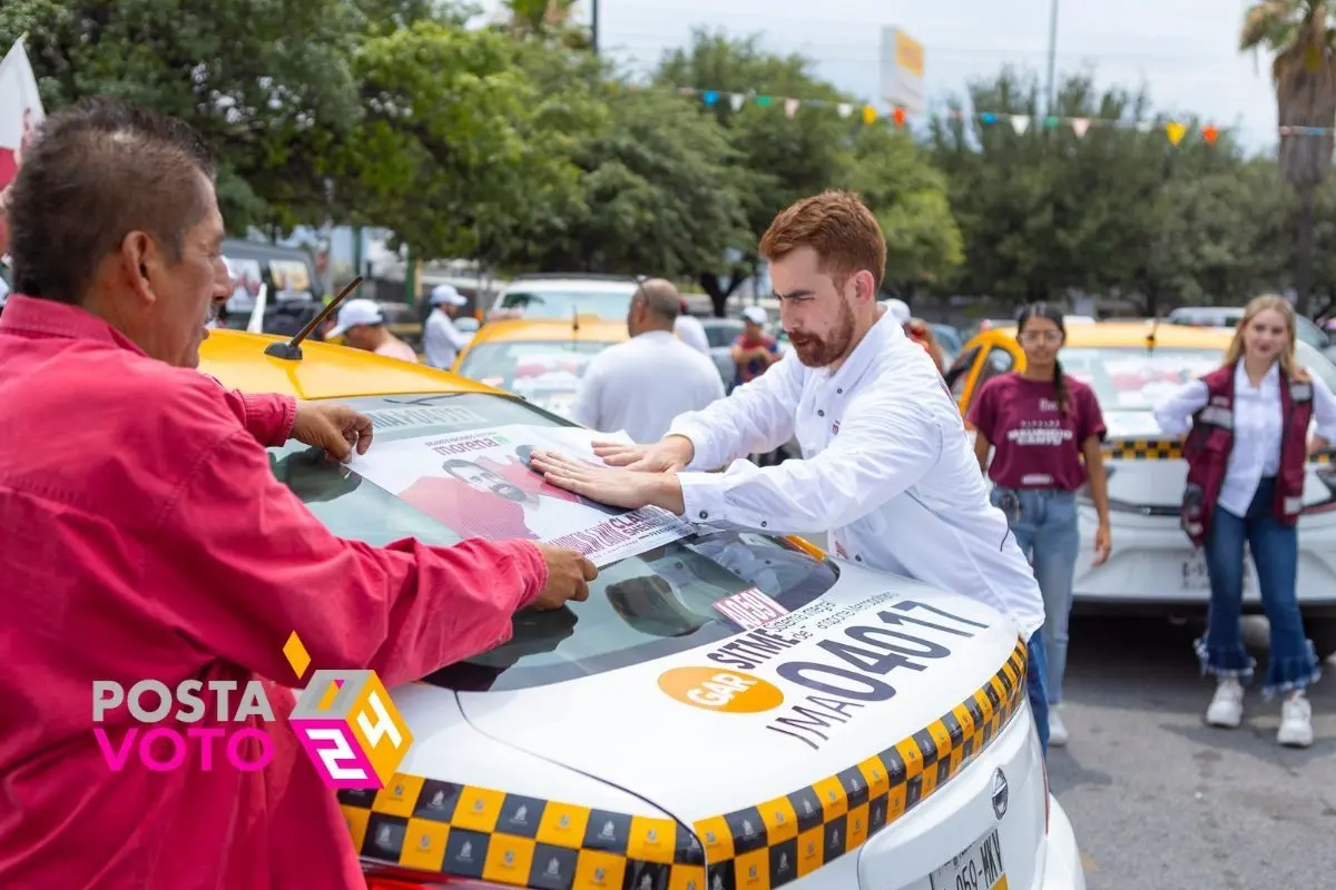 El candidato a la alcaldía de Monterrey por Morena y el Partido Verde, Mauricio Cantú, pegando calcas de su campaña electoral en un taxi. Foto: Morena NL