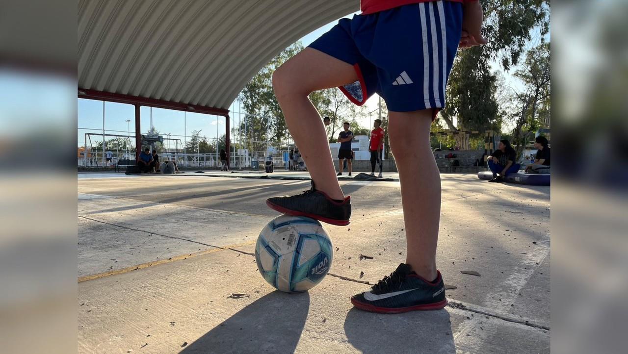 Un niño posando su pie sobre un balón de futbol. Foto: Isaura Retana.