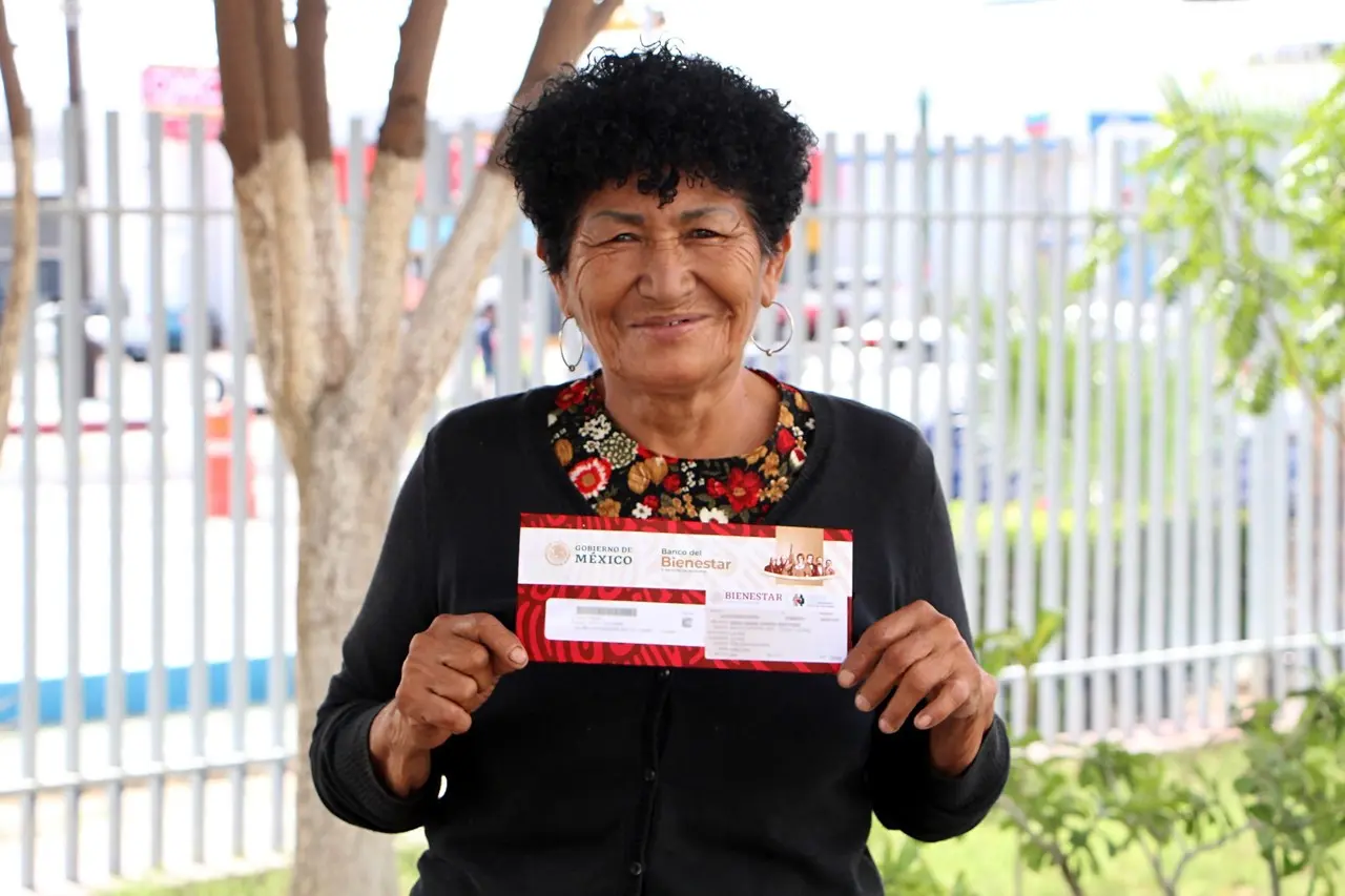 Adulto mayor recibiendo su tarjeta bienestar para pago de pensión adultos mayores. I Foto: Gobierno de BCS.