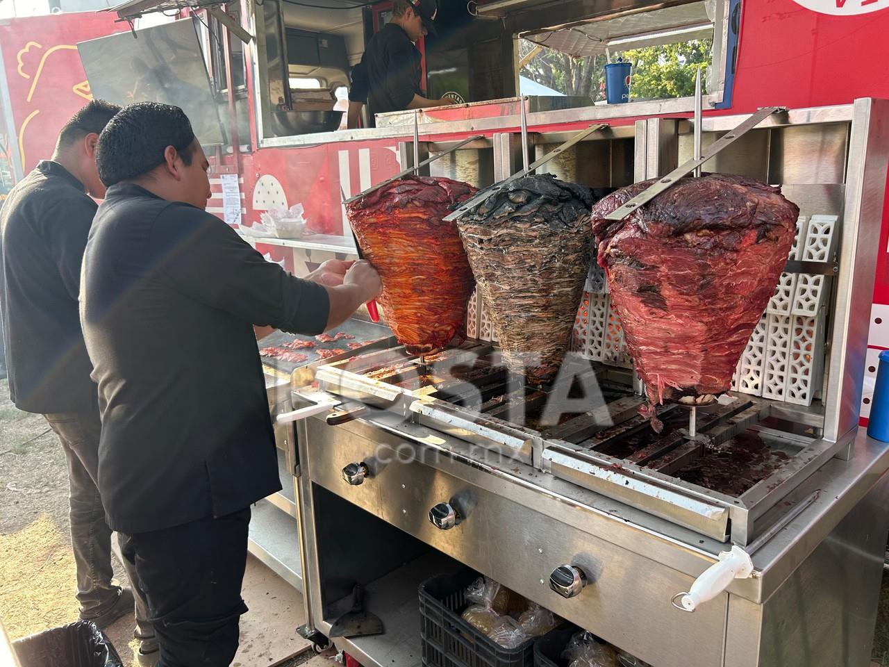 Taqueros cortando carne del trompo para hacer tacos. Foto: Jorge López-