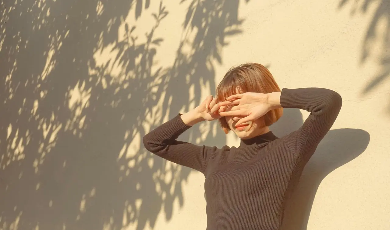 Mujer posa frente al sol. Foto: Pexels