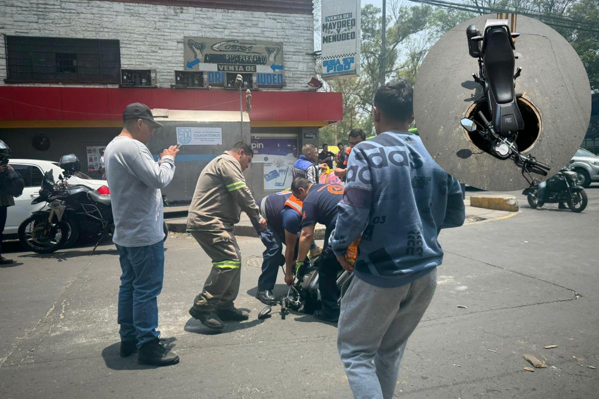 Personal ayudando a motociclista que se fue a una coladera, moto en coladera sin tapa. Foto: Ramón Ramírez