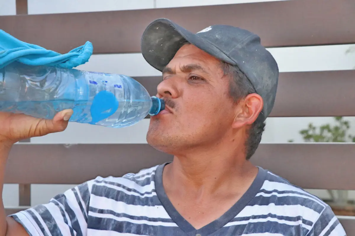 Hombre tomando agua para prevenir golpes de calor. Foto: Gobierno de BCS