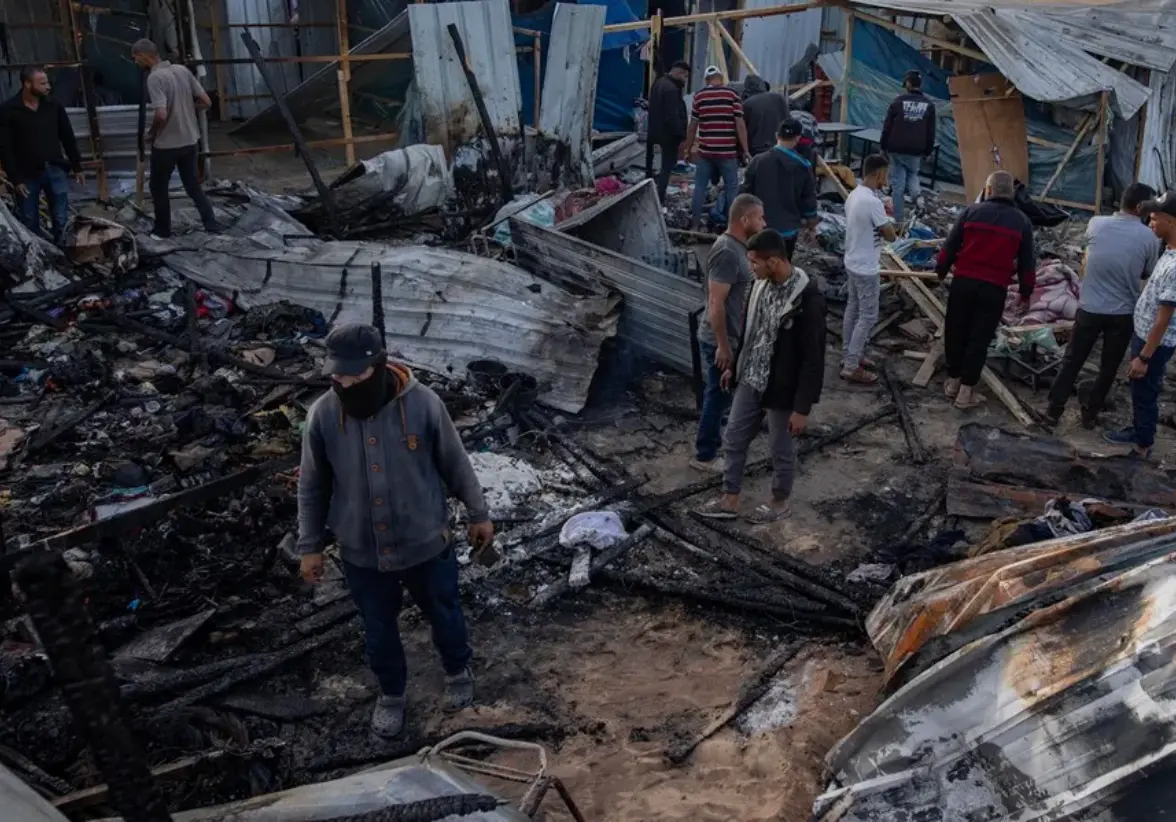 Palestinos inspeccionan los daños causados por un ataque del Ejército israelí en un campamento de una zona designada segura para desplazados en Rafah. Foto: EFE