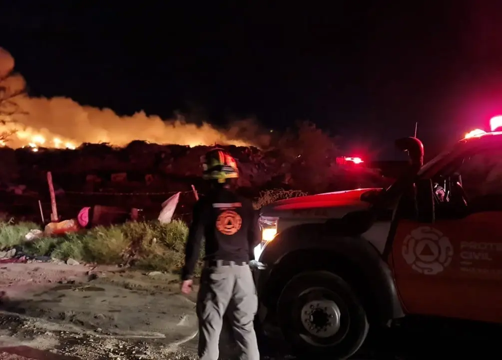 Un miembro de Protección Civil Nuevo León, observando como el incendio consume parte del basurero. Foto: Protección Civil Nuevo León.