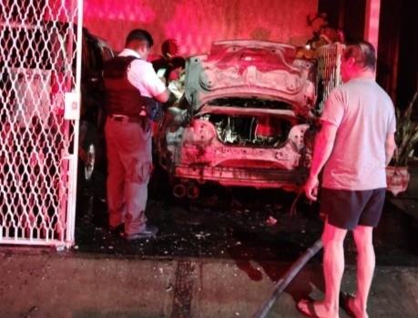 El auto que sufrió el incendio y las autoridades tomando nota de lo ocurrido junto a uno de los dueños. Foto: Policía de Monterrey.