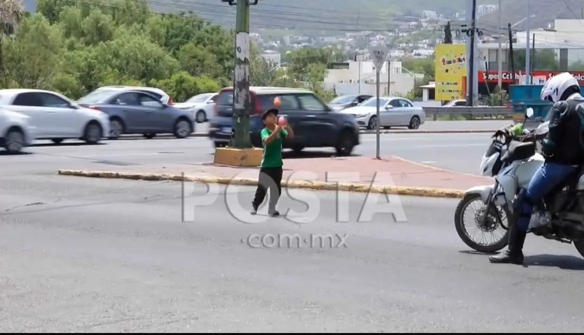 Un niño migrante haciendo malabarismo para poder conseguir que le den dinero en la calle. Foto: Rosy Sandoval.