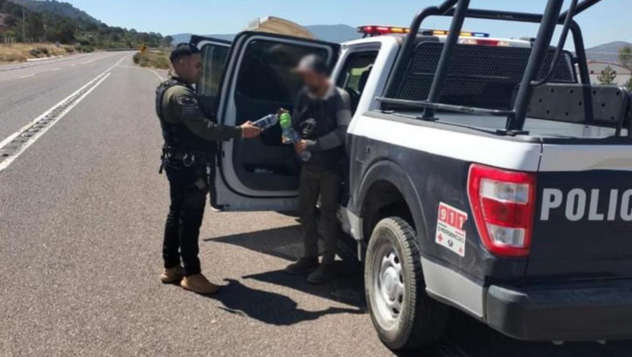 Elementos de la Policía Municipal dotando de agua al hombre que caminaba con destino a Zacatecas. Foto: Facebook SSP Durango.