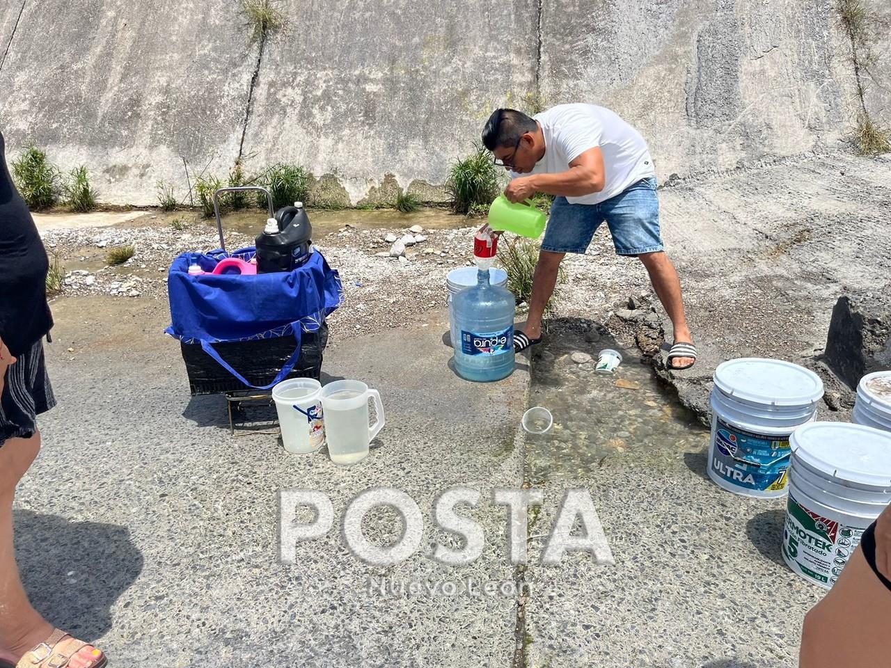 Un hombre recolectando agua de un arroyo. Foto: Rafael Enríquez