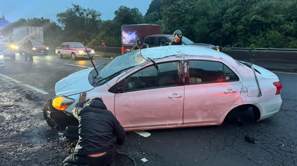 Auto compacto vuelca en la México- Toluca, conductor derrapó por piso mojado