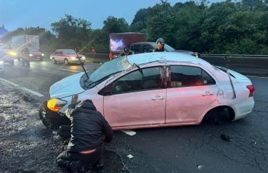 Auto compacto vuelca en la México- Toluca, conductor derrapó por piso mojado