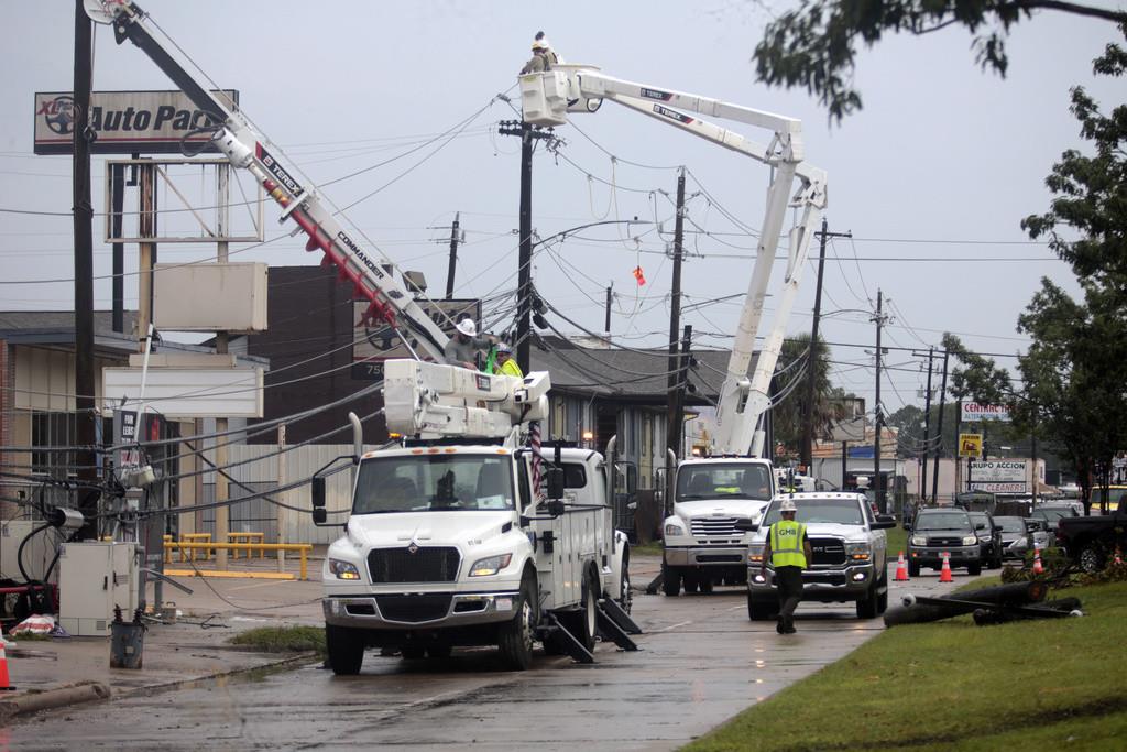 Trabajadores de servicios públicos trabajan para restablecer el suministro eléctrico en Houston, jueves 11 de julio de 2024. (AP Foto/Lekan Oyekanmi)