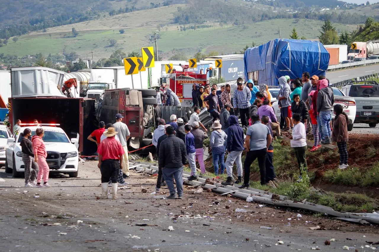 Personas acercándose al trailer que se volcó. Foto: Especial