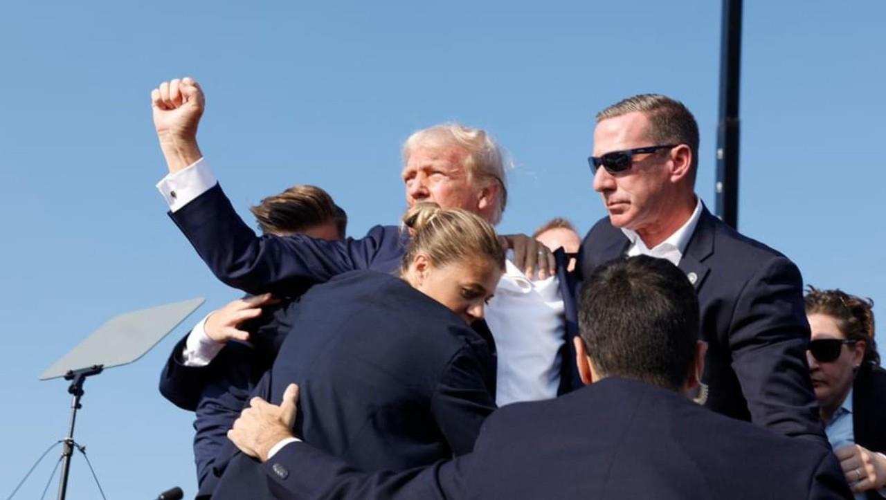 Trump antes de ser evacuado del lugar del atentado rumbo al hospital. Foto: Facebook Debate.