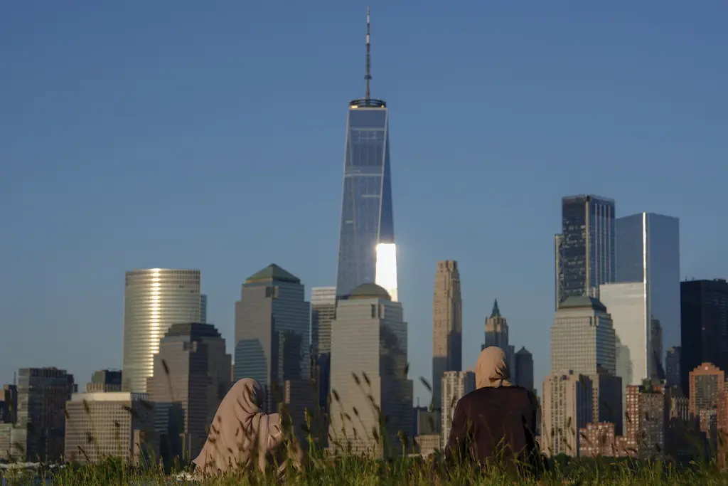 -Un grupo de personas mira el horizonte de Ciudad de Nueva York al atardecer, el domingo 16 de junio de 2024, en Jersey City, Nueva Jersey. (AP Foto/Julia Nikhinson, Archivo)