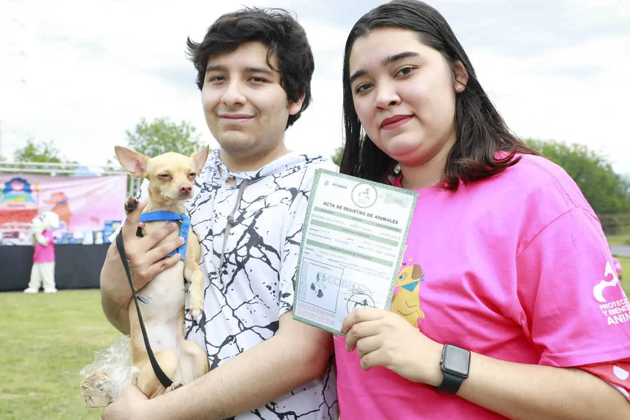 Jóvenes con su perrito y una acta. Foto: Gobierno de Escobedo