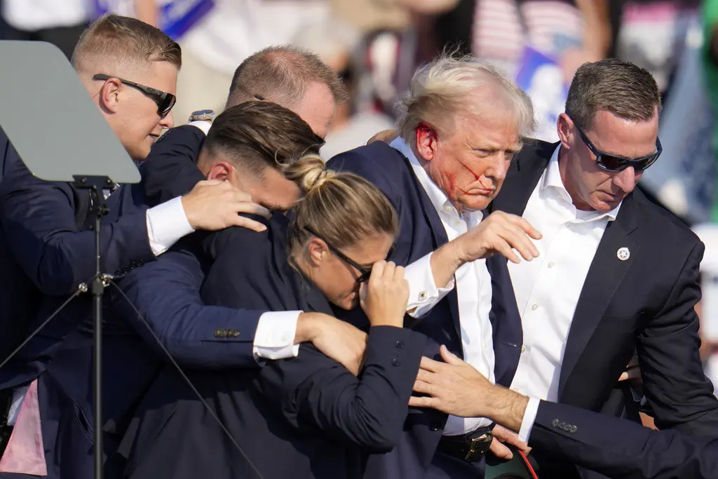 El candidato presidencial republicano, el expresidente Donald Trump, es ayudado a bajar del escenario por agentes del Servicio Secreto de Estados Unidos en un acto de campaña en Butler, Pensilvania, el sábado 13 de julio de 2024. (AP Foto/Gene J. Puskar)