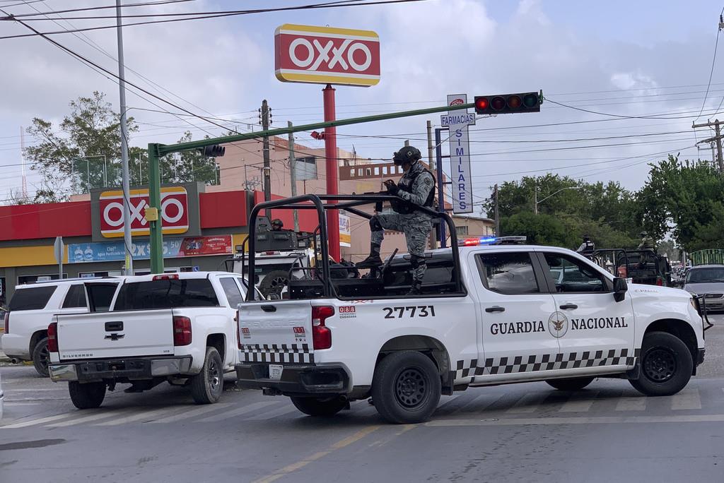 Soldados mexicanos montan guardia frente a una tienda de abarrotes Oxxo, cerca de la Cámara de Comercio de Tamaulipas, donde fue asesinado su presidente Julio César Almanza, en Matamoros, México, martes 30 de julio de 2024. (AP Foto/Veronica Cisneros)