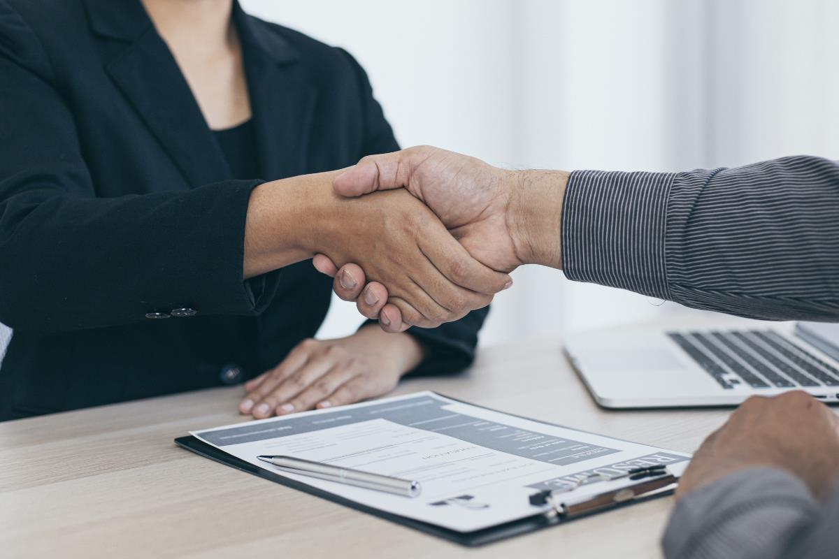 Personas dándose la mano en una entrevista de trabajo. Foto: Canva