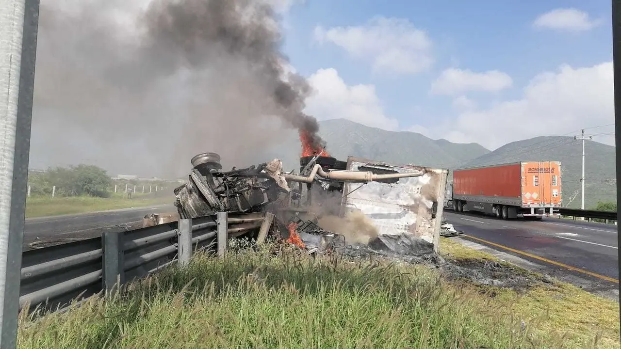 La unidad de carga pesada volcada tras el choque e incendiada. Foto: Protección Civil de Nuevo León.