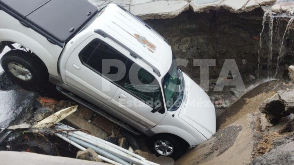 Camioneta queda atrapada al caer en enorme socavón en el municipio de Ecatepec