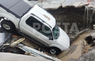 Camioneta queda atrapada al caer en enorme socavón en el municipio de Ecatepec