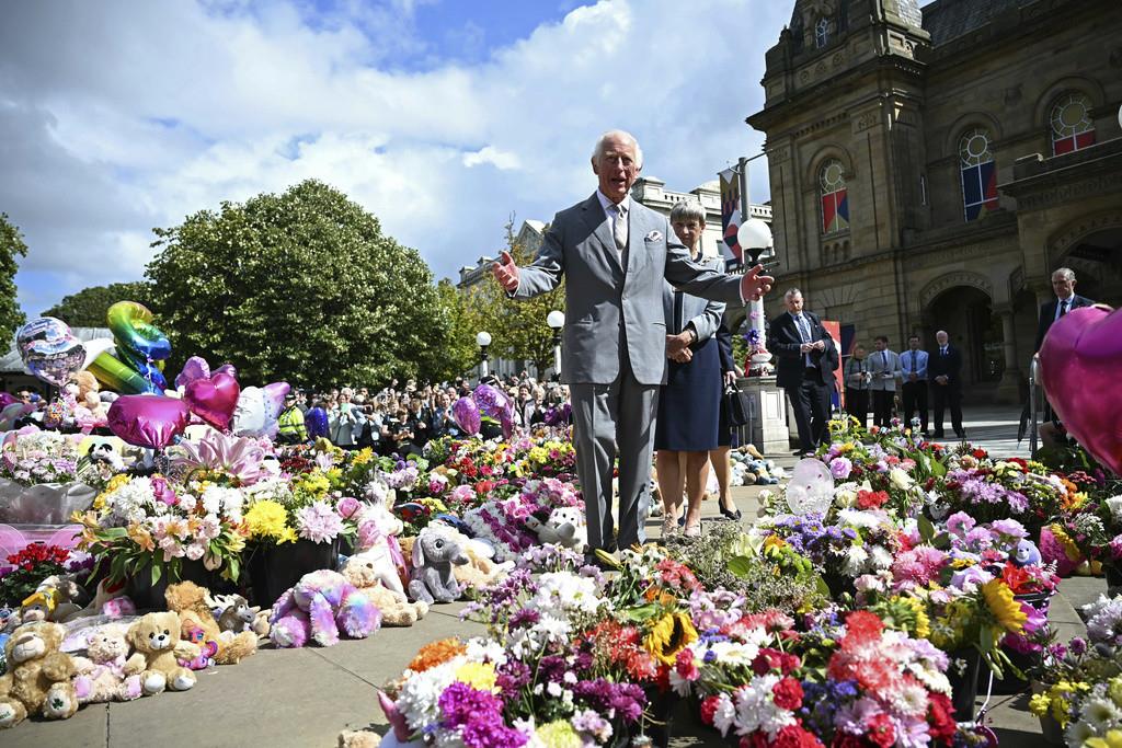 El rey Carlos III de Gran Bretaña mira ofrendas frente al Ayuntamiento de Southport, en Southport, Inglaterra, el martes 20 de agosto de 2024, mientras se reúne con miembros de la comunidad local, luego del ataque del 29 de julio en una clase de baile infa