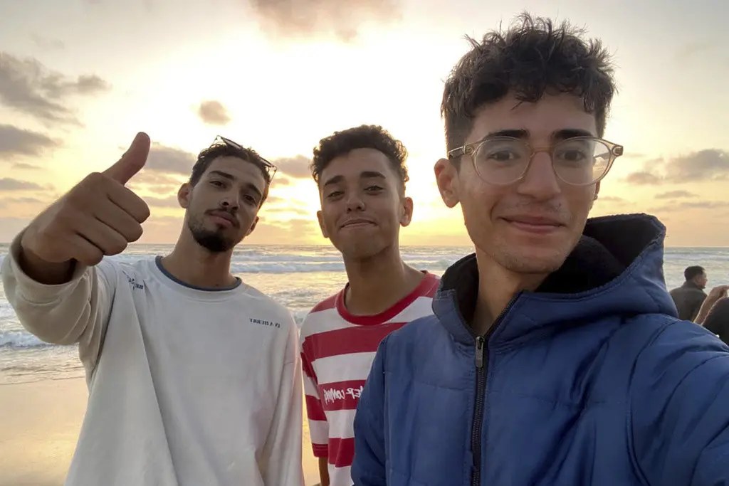 En esta fotografía sin fecha proporcionada por Helmi Hirez, se muestra a Mohamed (Medo) Halimy (izquierda), y a los hermanos gemelos Mohammed Hirez (centro) y Helmi Hirez, en una playa de la Franja de Gaza. (Helmi Hirez vía AP).