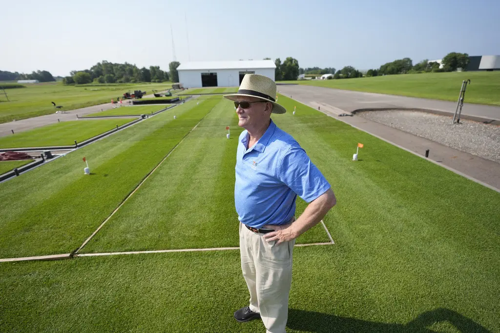 Trey Rogers, experto en césped de la Universidad Estatal de Michigan, se para en una superficie de pasto en Lansing, el miércoles 31 de julio de 2024 (AP Foto/Carlos Osorio)