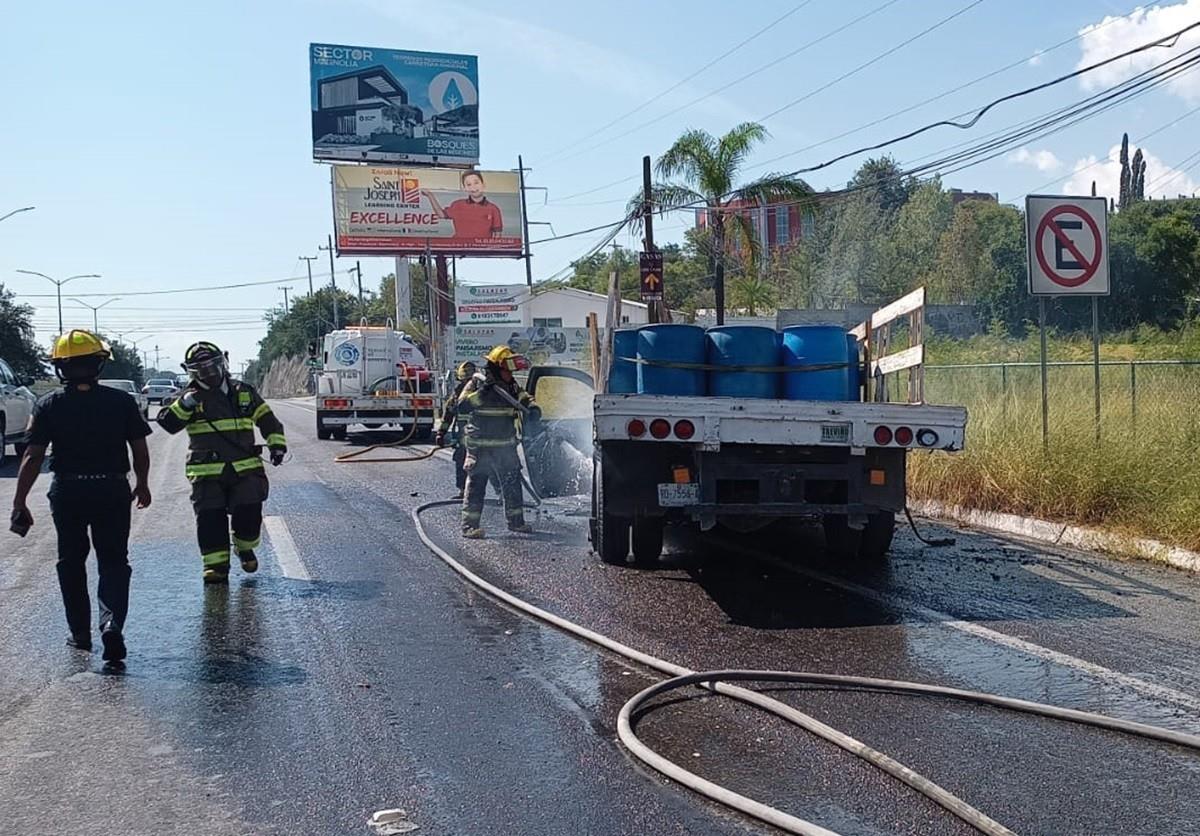 Elementos de Protección Civil realizan maniobras para sofocar las llamas en una camioneta de redilas en la carretera Nacional.  Foto: Raymundo Elizalde