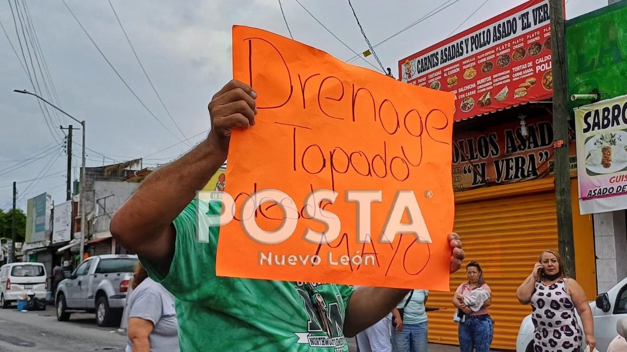 Vecino protestando con un cartel sobre las fugas en el drenaje. Foto: Diego Beltrán.
