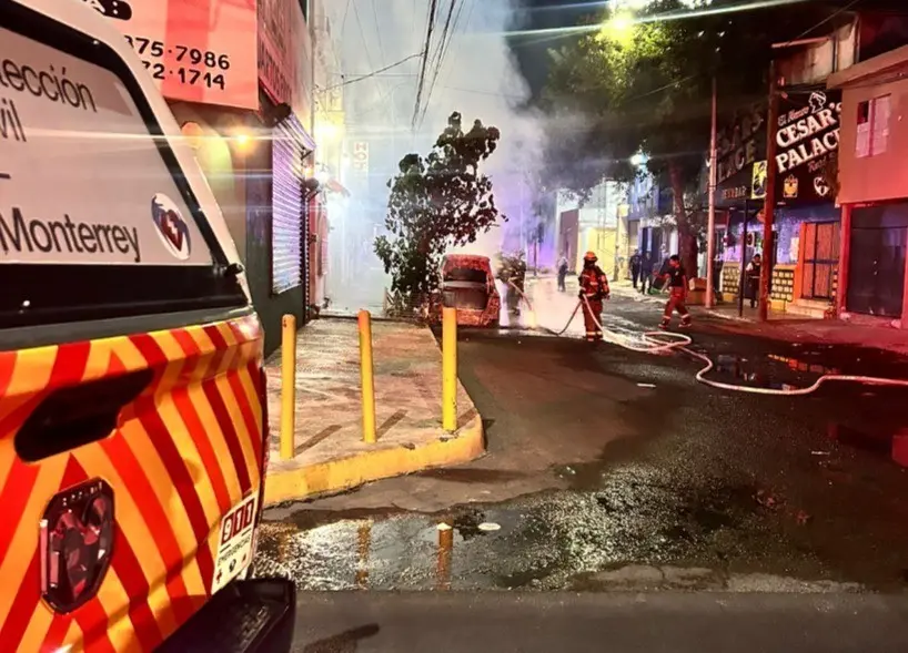 Bomberos y rescatistas sofocando las llamas que consumían al vehículo. Foto: Protección Civil de Monterrey.