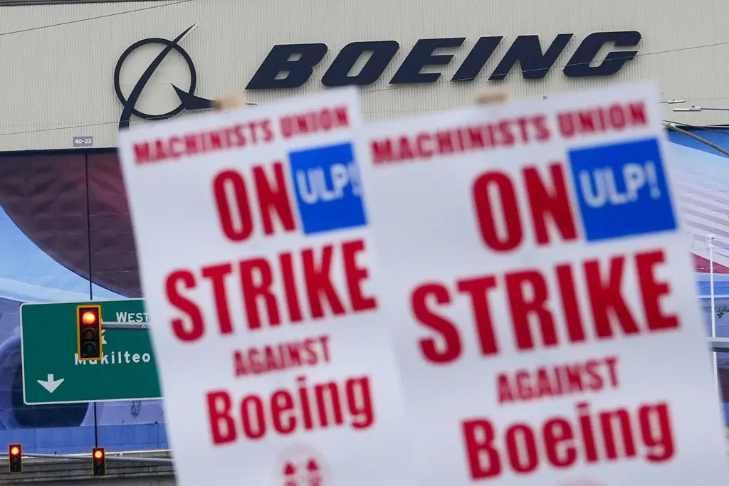 Trabajadores de Boeing sostienen letreros de huelga durante una protesta luego de que miembros sindicales rechazaron una oferta de contrato, el domingo 15 de septiembre de 2024, cerca de la fábrica de la compañía en Everett, Washington. (AP Foto/Lindsey Wa