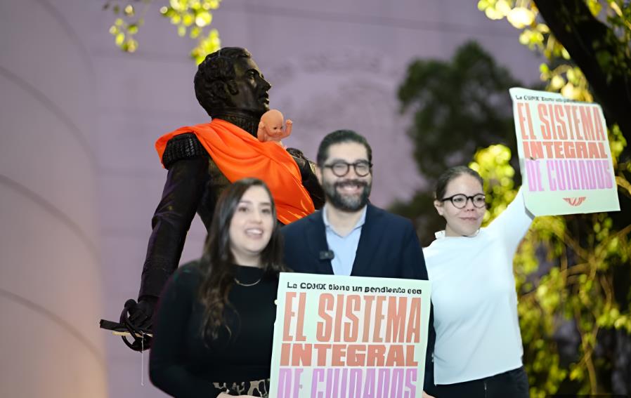 Integrantes de Movimiento Ciudadano frente a estatua con mandil naranja. Foto: @MovCiudadanoCMX