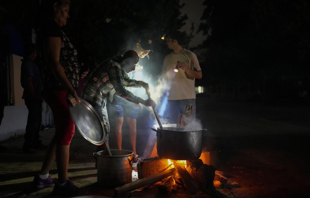 Personas preparan una sopa en una fogata durante un apagón que siguió a la falla de una importante planta energética en La Habana, Cuba, el sábado 19 de octubre de 2024. (AP Foto/Ramón Espinosa)