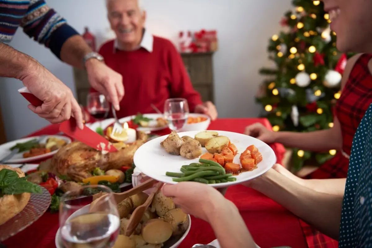 Personas en una Cena de Navidad. Foto: Freepik editada en Canva.
