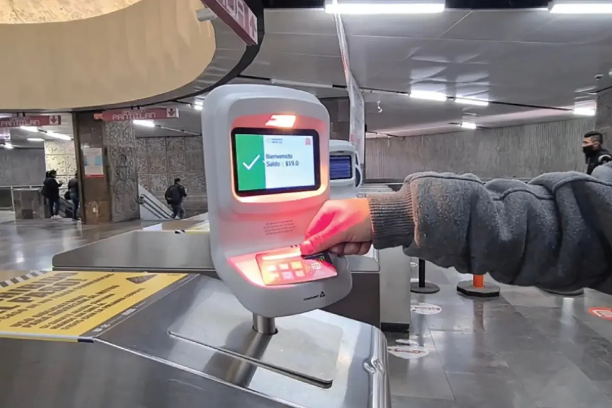 Persona colocando su tarjeta en el torniquete del Metro para acceder al servicio.   Foto: @MetroCDMX