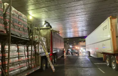 Tráiler cargado de refrescos, se atora bajo un puente por exceder altura permitida