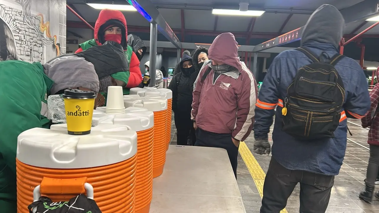 Personas que se dirigen a su trabajo desde temprano recibiendo una bebida caliente. Foto: Rosy Sandoval.