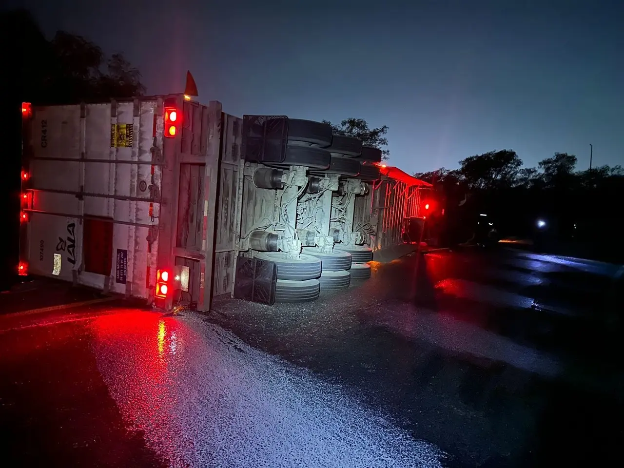 Tráiler de carga después de haber volcado. Foto: Protección Civil de Nuevo León.