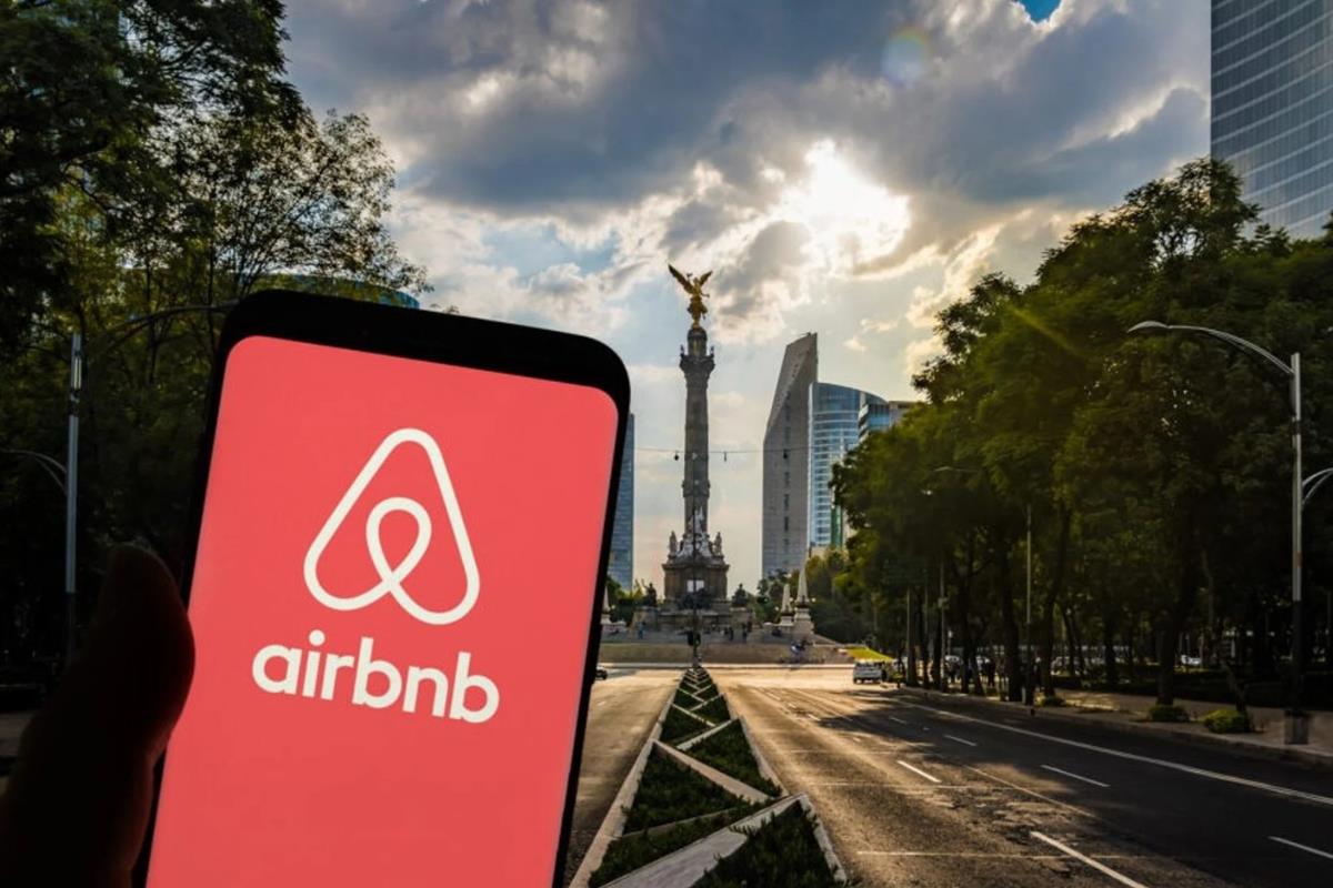 De fondo el Ángel de la Independencia, celular con Airbnb. Foto: @porktendencia