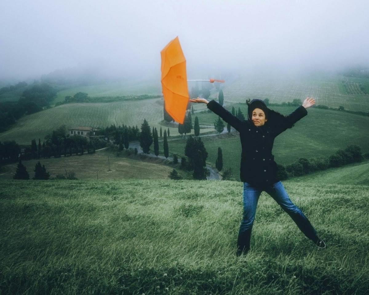 Mujer en medio de una fuerte racha de viento por el frente frío 28. Foto: Canva.