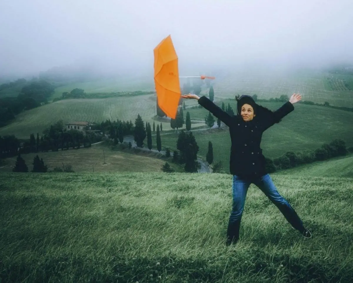 Mujer en medio de una fuerte racha de viento por el frente frío 28. Foto: Canva.