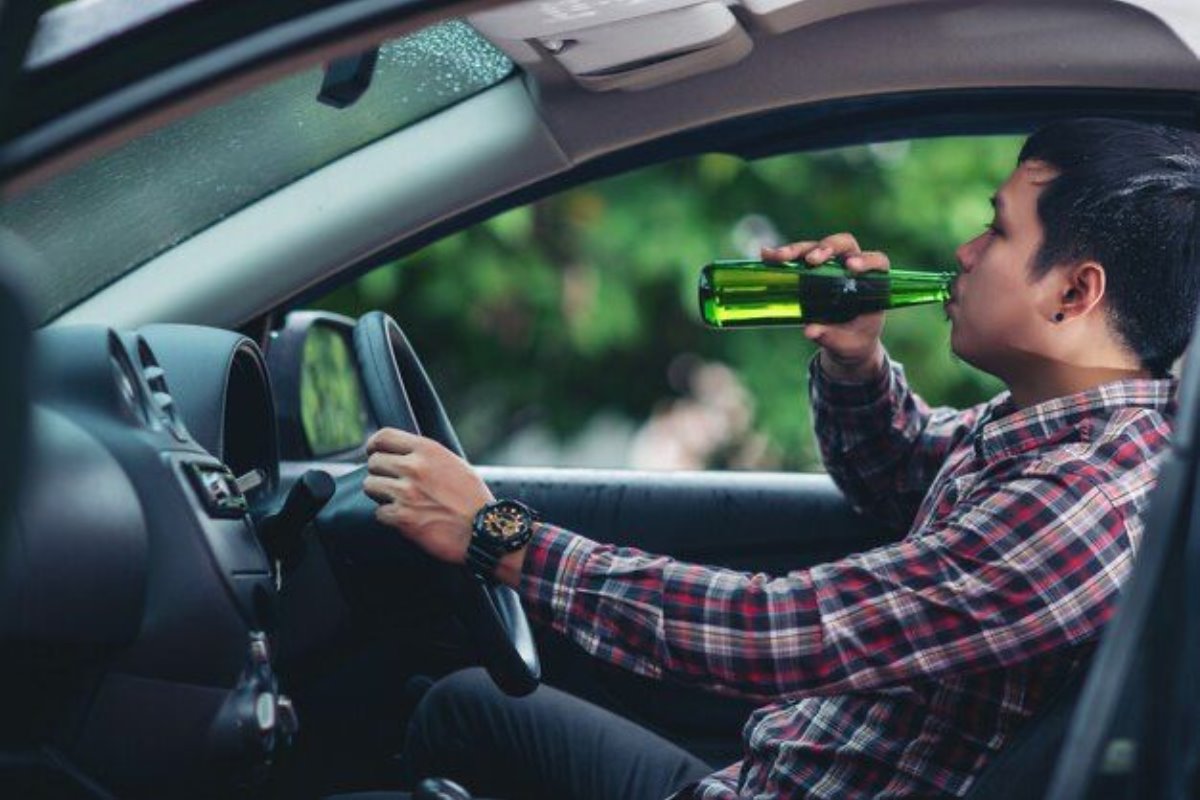 Joven tomando alcohol mientras manjea