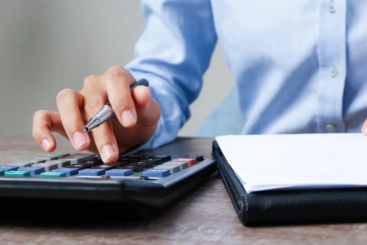 Persona calculando las utilidades del 2025. Foto: Freepik
