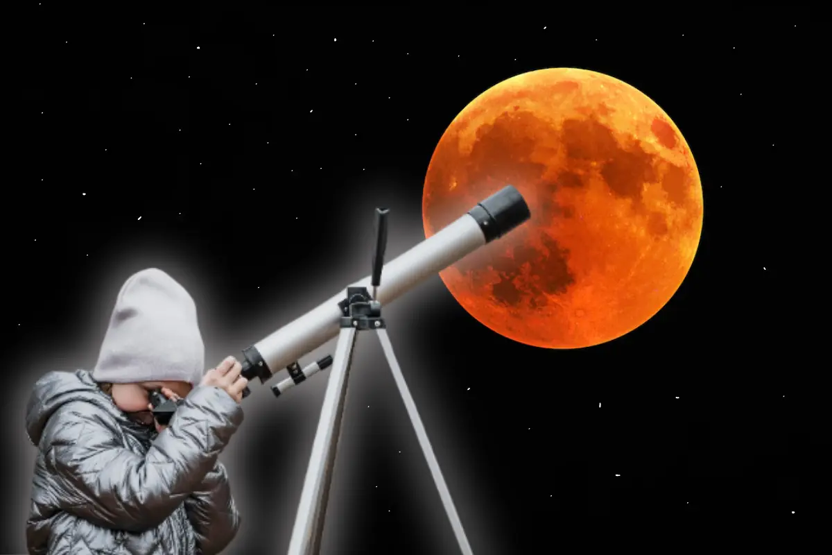 Niña viendo el eclipse de Luna a través de un telescopio. Foto: Freepik | Canva