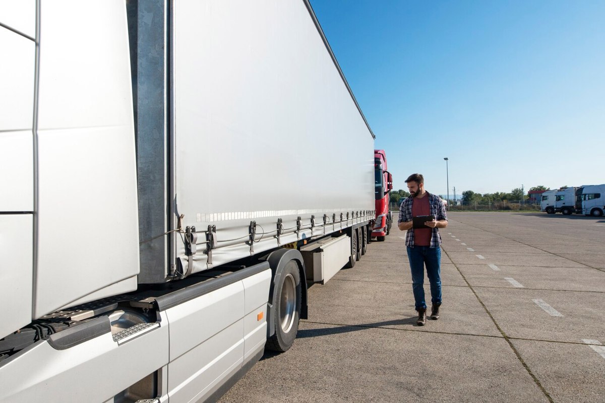 Trailero inspeccionando su trailer. Foto:Freepik