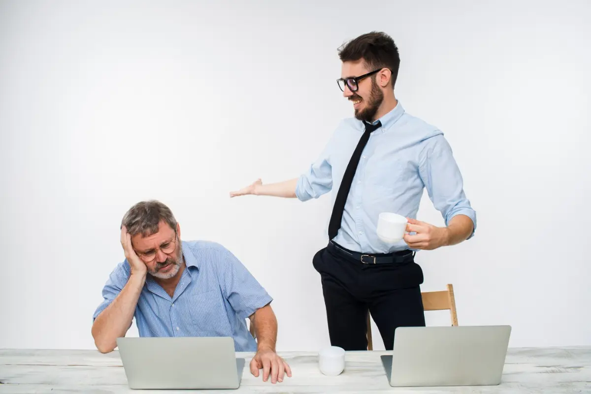 Jefe estresado por el pago de utilidades con su empleado a un lado. Foto: Freepik
