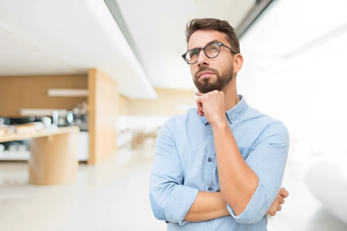 Persona pensando en el pago de utilidades frente a una oficina. Foto: Freepik | Canva